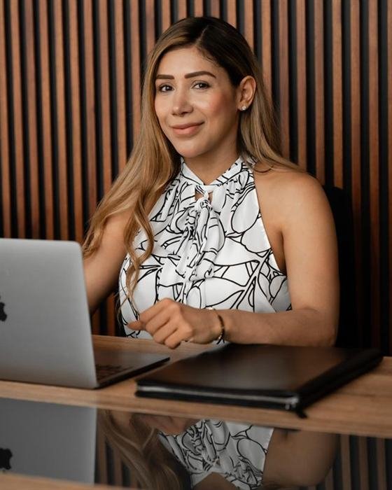 Itzel García trabajando en su oficina frente a su computadora, lista para atender a sus clientes