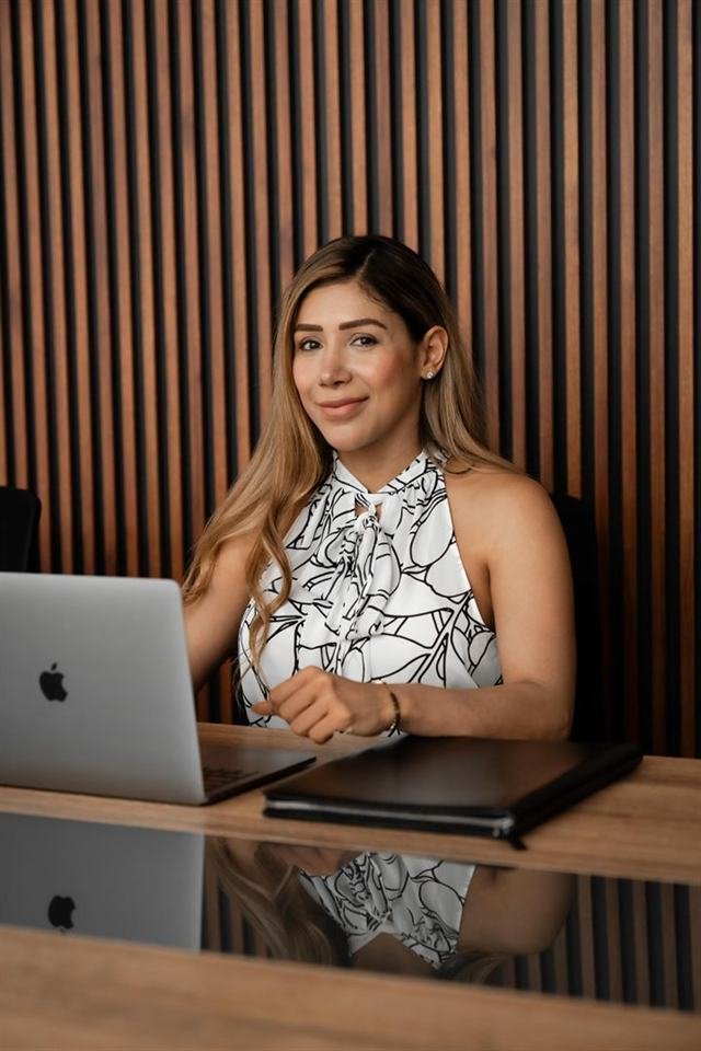 Itzel García sentada en el escritorio de su oficina, frente a su computadora